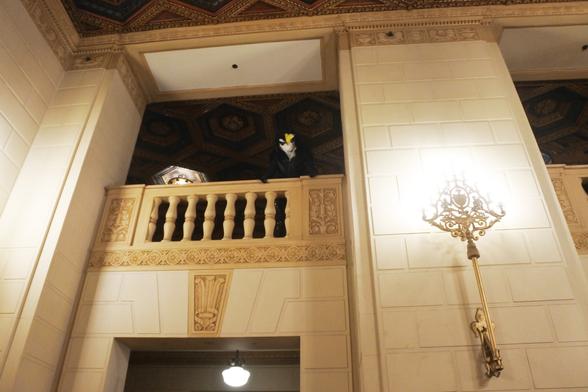 Fursuit photo: Night-time shot of Terry the dragon in the rear foyer of the Omni hotel in Pittsburgh.  This is a shot from the foyer - the dragon is on the upper floor, leaning out over the balcony to look at the camera