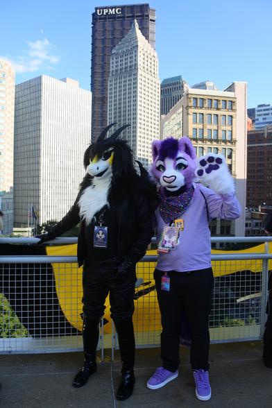A dragon fursuiter and a lavender cat on the roof of the DLCC building