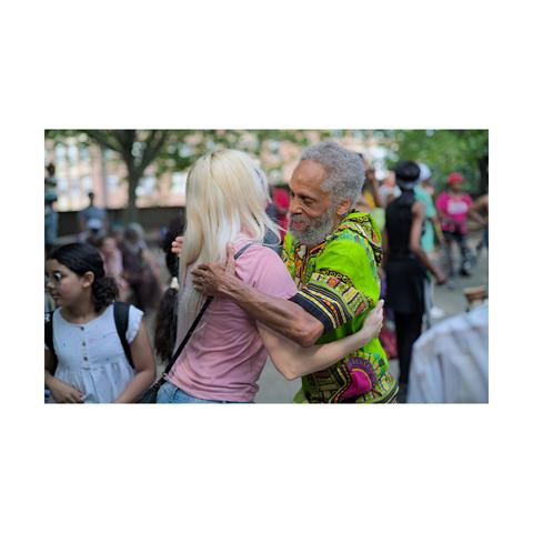 A casual street portrait of a woman greeting his male friend.