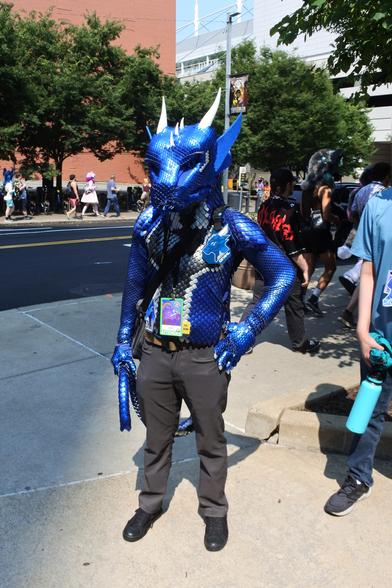 Fursuit photo - Drakl, a blue dragon fursuit made largely of scale-mail from the waist up.  The use of different scale sizes on the arm gives his arms a muscular look.