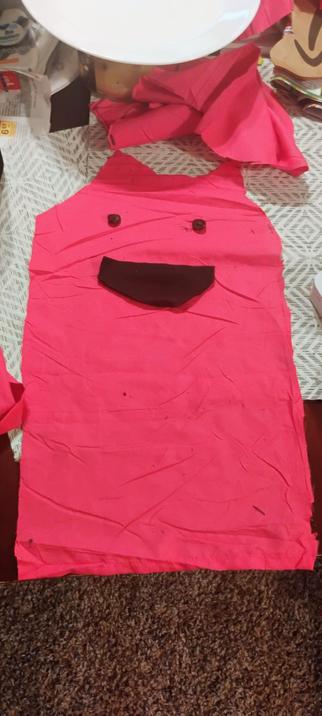 outline for a long hot pink cat plushie cut out with buttons for eyes and a fabric mouth