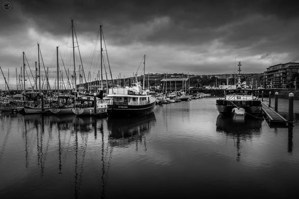 Monochrome shot of whitehaven harbour with mix of commercial and pleasure boats at dock