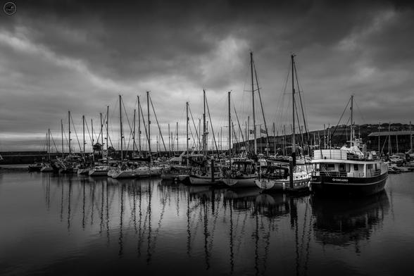 Monochrome shot of whitehaven harbour with mix of commercial and pleasure boats at dock