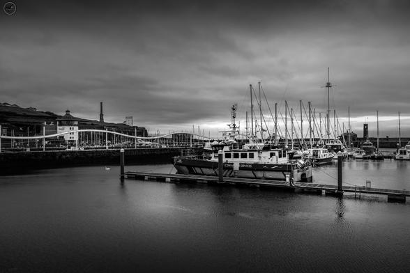 Monochrome shot of whitehaven harbour with mix of commercial and pleasure boats at dock