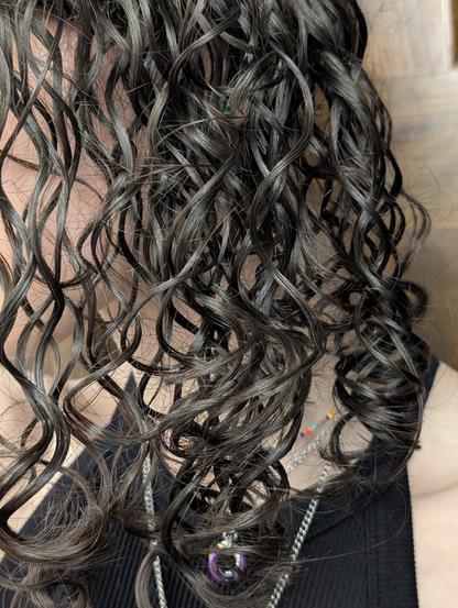 A picture of this enby looking off to the side. It's a close up of their hair. They're wearing a ribbed black tank top, a longer stainless steel chain with an unseen pendant. Their non-binary pendant day collar and a slim choker made with rainbow beads on a thin stainless steel wire. 

The helical brunette ringlets dominate the frame obscuring basically all facial features, including the ears and eyes. The spiraling brunette twirls tightening as they lengthen help you surf the texture of their words and sounds. You wonder what sort of music might be trapped in those strands as you find your consciousness moving alongside, part of the hypnotic pattern embedded in those coils. 


Will you struggle? Or will you comply? Even if just to see what happens?