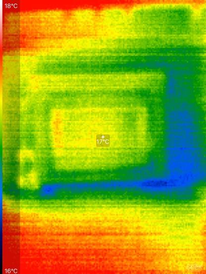 Thermal camera image around a fireplace. Showing leaks around the bottom and right edge of the fireplace