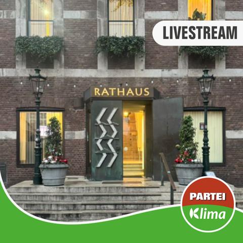Nahaufnahme des Haupteingangs des Düsseldorfer Rathauses. Die Tür ist geöffnet und gelbes Licht ist im Inneren zu sehen.