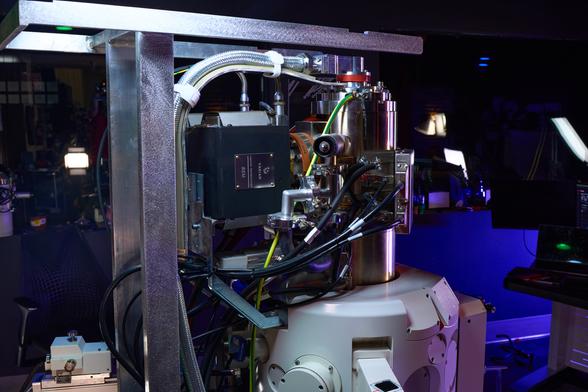 Picture of Zeiss Mirrors on an electron microscope upper column with panels removed and some aesthetic bright white lighting.