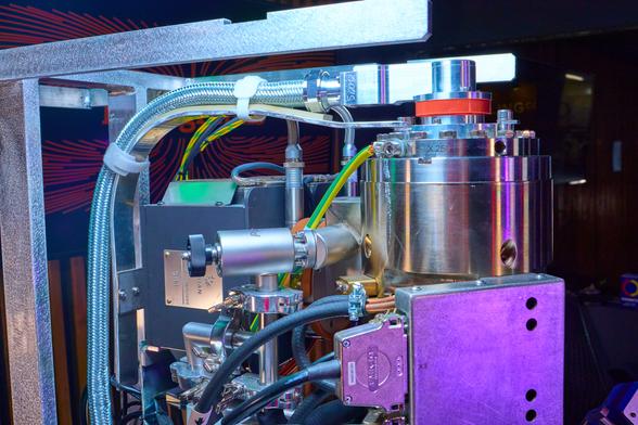 Photo of Zeiss Merlin electron microscope with some purple lighting. Upper column section panels removed.