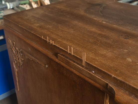 Furnier Reparatur, hier: Blick von schräg oben auf die angeleimten Furnierstücke