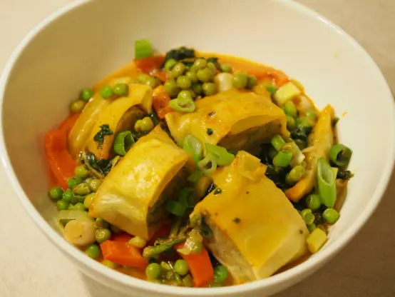 Eine Portion der asiatisch zubereiteten Maultaschen mit einem Gemüse in einer Sauce aus Kokosmilch und roter Curry Paste.
