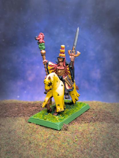 Miniature of a mage riding a horse. The mage robes are yellow and red with a dark blue trim, with a large hat over his head. On one hand, he's holding a sword, on the other hand a staff with statues of a lion and a snake. The horse is covered in a yellow cloth decorated with black stars.