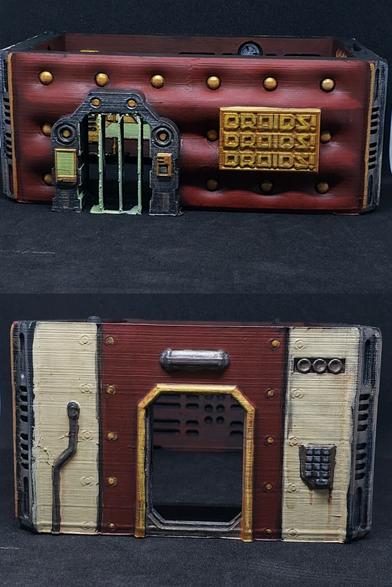 Front and side door of a rectangular building. The front looks like it's has oversized upholstery in a rich red with gold buttons and a gold sign saying "DROIDZ! DROIDZ! DROIDZ!"
The side door is good trimmed with red paneling, but grubby cream paneling to either side.