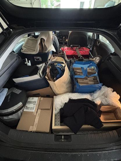 Spacious hatchback trunk of a Hyundai Ioniq loaded with bags and boxes of display equipment, transaction essentials, and the art of course (with room to spare!), in preparation to sell at Edmonton's Whyte Avenue Art Walk.