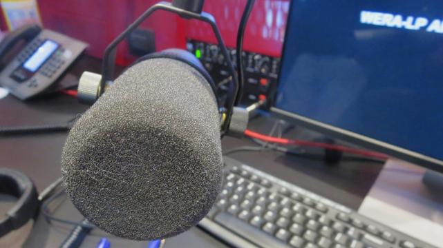 A close-up of a microphone in WERA's studio in December of 2015, with monitor visible in the background showing "WERA-LP" on its screen.
