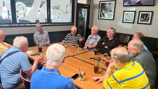 Andrew speaking with a group of Edmontonians around a table.