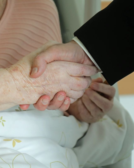 Zwei Hände halten sich fest.