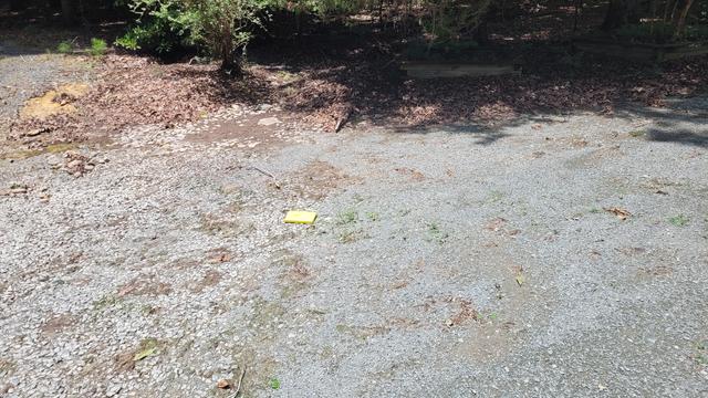 Two toned gravel driveway after a flood event. To the left of the yellow notebook, smaller gravels were washed away.