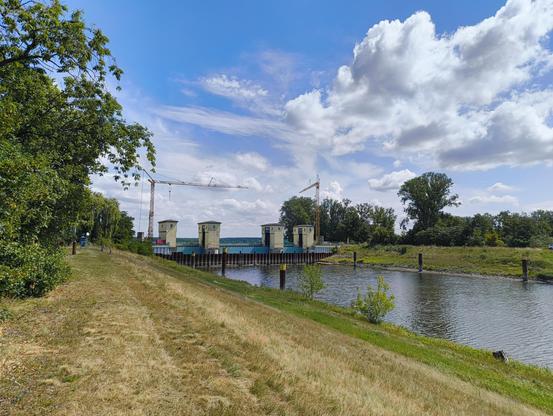 An der Wehrgruppe Quitzöbel 🫡
Hier fließen die Havel und ein Teil des Elbe-Havel-Seiten-Kanals in die Elbe. Für jedes Gewässer gibt es ein massives Wehr, so dass bei Hochwasser der Wasserstand besser reguliert werden kann. Im Bild ist eines der drei Wehre zu sehen. Es spannt sich über das Wasser und zwischen den vier Türmen sind massive Stahlwände eingebaut, die über Kettenzüge in den Türmen gehoben oder gesenkt werden können. Links und rechts des Wehrs stehen große Baumkräne.