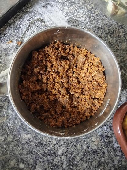 Foto de una olla pequeña que contiene la mezcla de harinas revueltas con la mantequilla y la melaza que serán la cobertura del crumble (la cobertura tienen la consistencia de migas que se desmoronan con las manos).