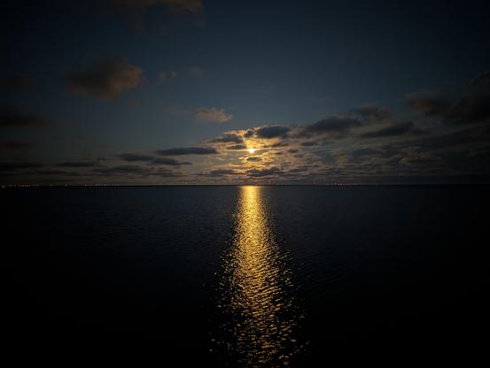 Yellow moon reflected on the water.