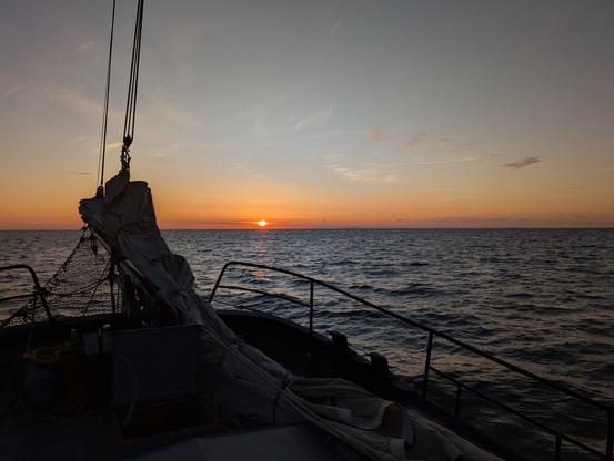 Sun setting in the sea as seen from a sailing ship