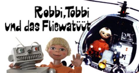 Junge und Roboter als puppen mit hubschrauber und text Robbi, Tobbi und das Fliwatüüt