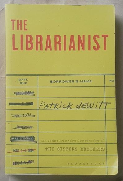 Patrick deWitt's The Librarianist, Bloomsbury paperback edition. The design, by Allison Saltzman, imitates a library card, using images from Shutterstock and Getty. It's yellow, with the author's name in the "Borrower's name" column, and various due dates crossed off to the left. The title is in red sans-serif at the top, and below the author's name is the text: "Man Booker Prize–shortlisted author of The Sisters Brothers".