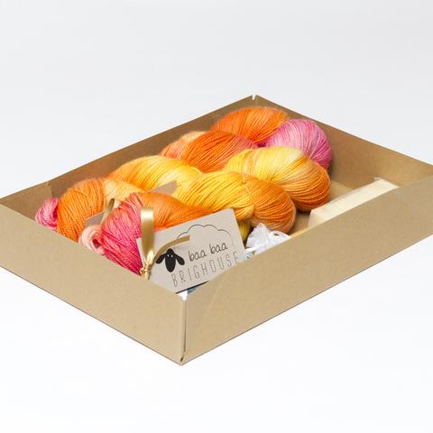 Picture shows an open A4 box containing two skeins of yarn. The other items are obscured by the sides of the box.