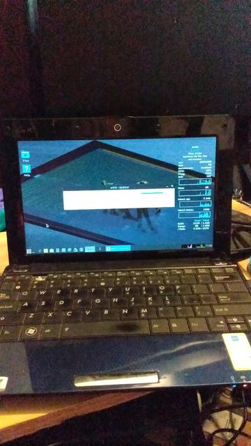 An old blue clamshell netbook running updates of AntiX on the screen.