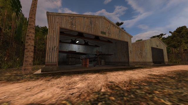 In this picture you can see two hangers. Around the two hangers is a metal fence and behind it is jungle vegetation. Next to the left hanger is a tree, on the left is a tree. In the left trailer is another Cessna. This is painted white and red. Behind the Cessna is four wooden boxes. In front of the Cessna there is a red barrel on the left and on the right wing (view from the front) there is a wooden board. To the right of the Cessna are wooden crates and a gray barrel. Furthermore, a white illuminated lamp hangs from the ceiling of the left hanger. This is on the map de_airstrip in the game Counter-Strike 1.6.