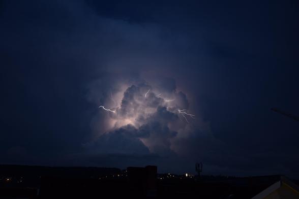 Aus der Gewitterwolke schlage nach links, oben und rechts kleine Blitze.