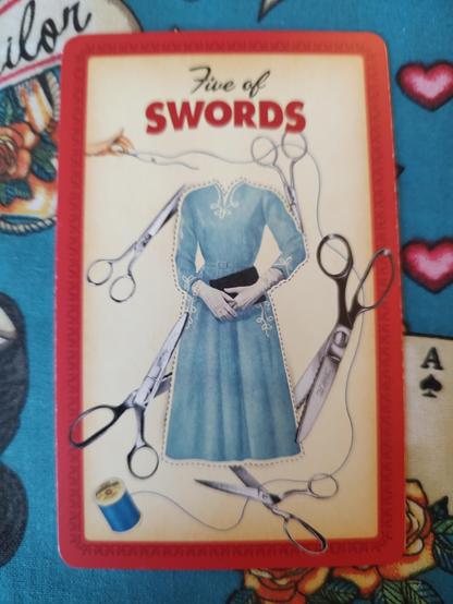 Card from the Housewives Tarot deck.
Five of Swords.
A photo of a woman's dress pattern, surrounded by scissors and rolls of thread.