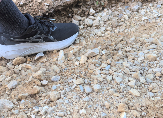 A closeup photo of one of the gulleys with my foot placed into it for scale. My (US size 11) shoe is nearly entirely below ground level