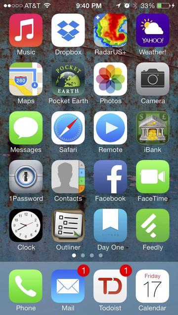 Screen capture of iPhone 5 from 2014, showing application icons against a colourful rusty painted steel wallpaper.