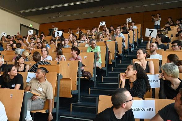 Auf dem Foto sieht man das Publikum im Hörsaal während der Abstimmung beim Golm Science Slam. Das Foto hat Antje Horn-Conrad aufgenommen.