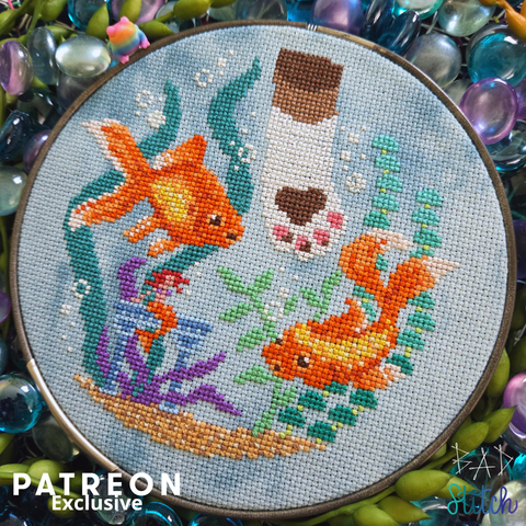 A silver hooped cross stitch project showing two goldfish trying to avoid a cat paw in their space. Patreon Exclusive. BAD Stitch.