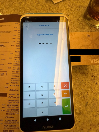 POS device in a restaurant showing "input your PIN" in Spanish and the digits are all scrambled