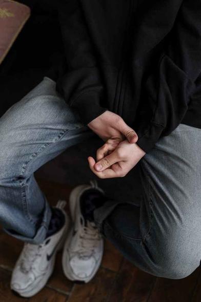 person in black jacket and gray denim jeans
