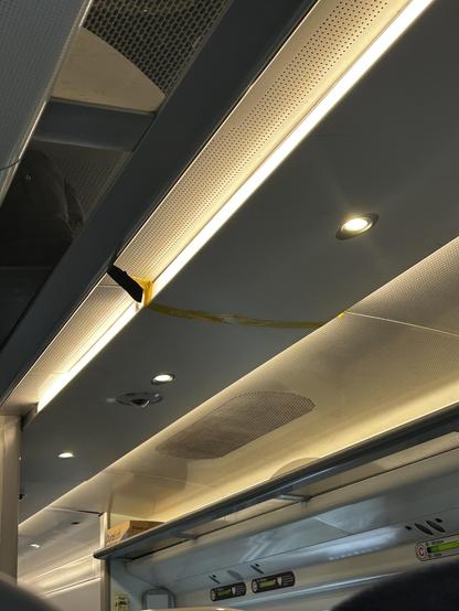A train roof panel held on with yellow tape