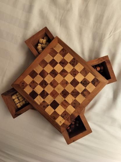 The chess board top turns open to reveal 4 small compartments holding pieces.