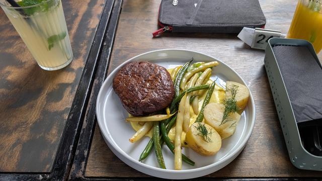 A plate with a vegan steak and sides.
