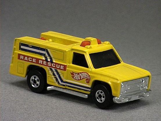 Released in 1985, Yellow Emergency Squad of 1985 Hot Wheels with Black Wall wheels. Notes: Has red hoses. Tampo: White and blue stripes on sides, with red and white 'Race Rescue' and Hot Wheels logo on sides. Packaging: 1985 Blister. Metal Body, Plastic Base. Made in Malaysia. Scarcity: 5/10