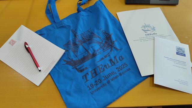 THEuMa swag: canvas shopper, folder and program flyer.