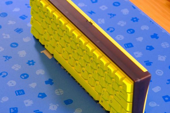 Luminkey60 LX (bright neon and dark polycarbonate keyboard) with GMK Hi! Viz keycaps on a blue Font Awesome deskpad