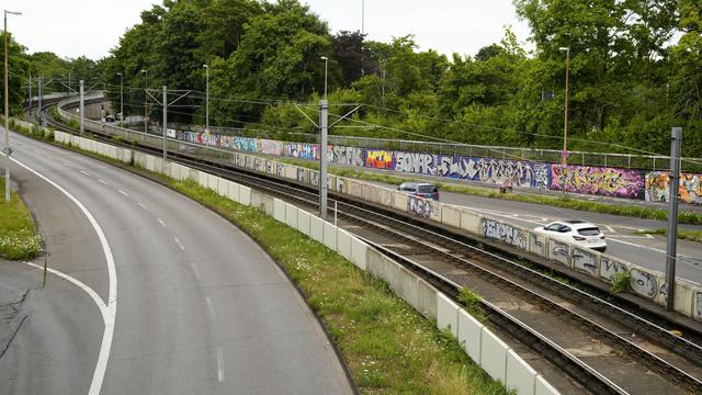 view from abridge onto two highways with tram railways inbetween and graffitied walls in the background