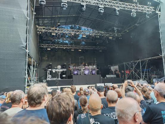 The stage prior to the band's performance with a large crowd standing before it. The purple monster dominates the stage.