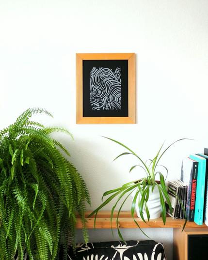 Abstract artwork in a frame on a wall.