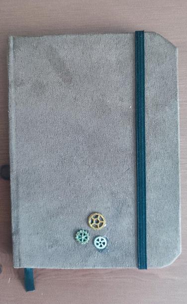 Handmade Moleskine-like notebook. Light Brown fabric bookcloth, and on the bottom side of the cover there are three small metal decoration gears.