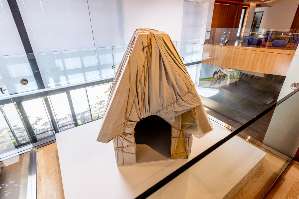 Wrapped Snoopy House, a life-sized doghouse wrapped in tarpaulin, polyethylene, and ropes. Photo by Brennan Spark, courtesy of the Schulz Museum.